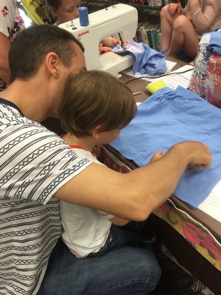 A dad & his lad pinning the bottom of the bag together