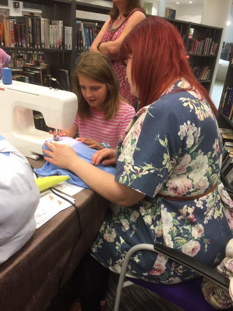 Rosie helping a young lady use the sewing machine