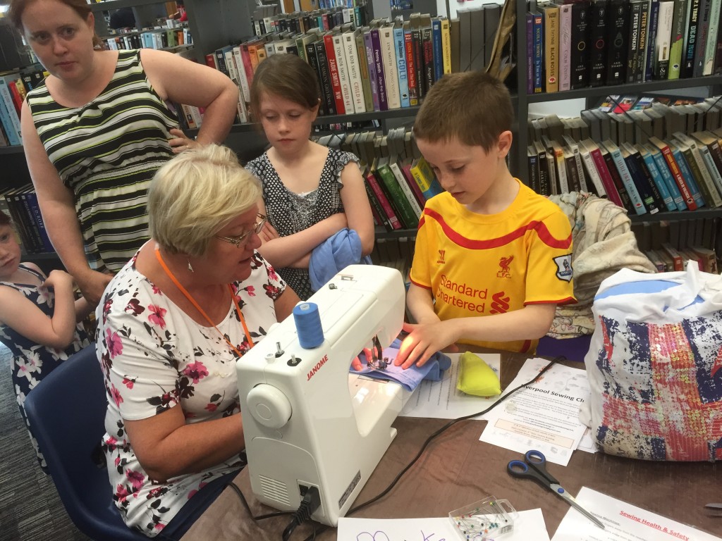 Jan showing a young family how the sewing machine works